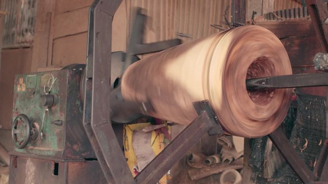 Workers forming long drum By using a rotating motor and using sharp object for forming