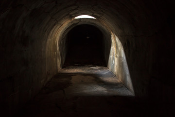 A gloomy, scary mystical underground passage with a skylight in the ceiling, attending a dark...