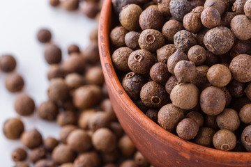 fresh spicy peppers allspice on white acrylic background