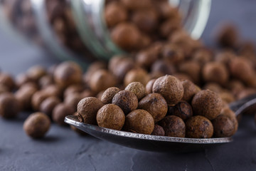 fresh spicy peppers allspice on a dark stone background