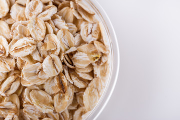 raw oat flakes on white acrylic background