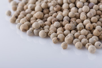 white peppercorns seed on white acrylic background