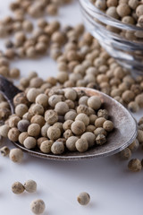 white peppercorns in glass bowl with spoon