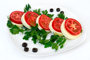 Mozzarella tomato and parsley on a plate on a white background