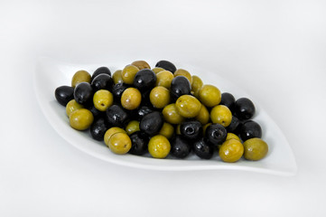 Black and green olives on a plate on a white background