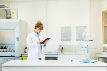 Scientist working on tablet in pharmaceutical laboratory