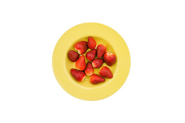 Strawberries in a yellow round plate. Red summer berries isolated on a white background. Flat lay, top view.
