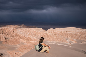 Woman sitting, enjoying dramatic scenery