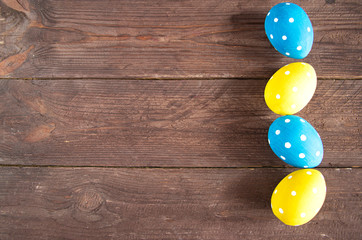 Easter holiday card. Classic blue and yellow colored eggs with white round spots. On a dark background. Copy space for text.