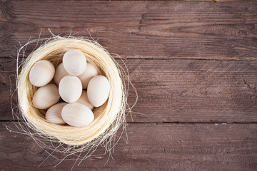 Easter holiday card. White little eggs in the nest. On a dark background. Copy space for text.