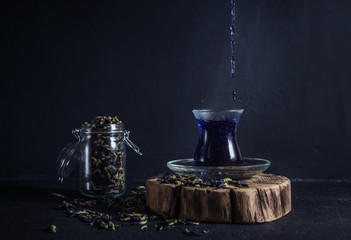 Obraz na płótnie Canvas tea in a glass cup on a dark background