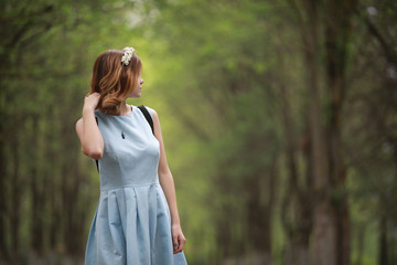 Girl in blue dress in green park