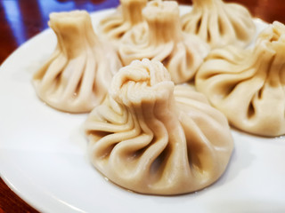 Delicious homemade Georgian traditional steamed dumplings called Khinkali filled with meats, coriander and meat's broth.