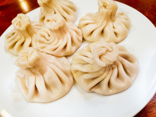 Delicious homemade Georgian traditional steamed dumplings called Khinkali filled with meats, coriander and meat's broth.