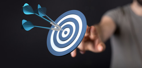 hand holding a target with darts hitting the center over white background. Concept of .