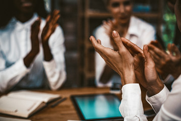 Happy Business People Applauds Together, Diverse Team Of Coworkers Celebrating Agreement With Business Partners While Sitting At Wooden Negotiation Table, Close Up Of Human Hands, Toned Image