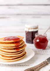 Tasty breakfast. Pancakes with strawberry confiture and butter.