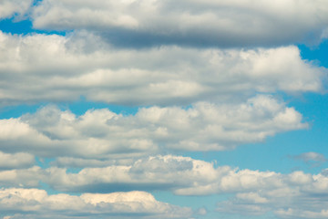 Snow-white light cumulus clouds against a blue sky