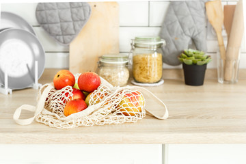 Apples in a string bag in kitchen table