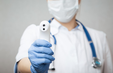 Doctor pointing infrared thermometer gun to check body temperature epidemic virus outbreak concept