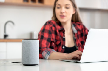 Fototapeta premium Woman talking to smart speaker. Smart home.