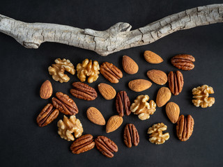 Various nuts on black wooden board, high resolution photo