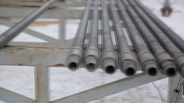 Oil Drill pipe. Rusty drill pipes were drilled in the well section. Downhole drilling rig. Laying the pipe on the deck. View of the shell of drill pipes laid in courtyard of the oil and gas warehouse.