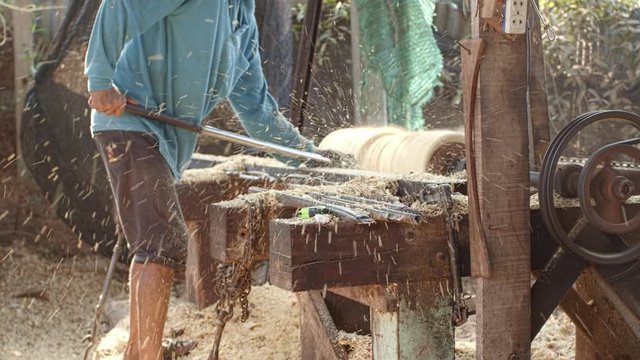 Workers forming long drum By using a rotating motor and using sharp object for forming