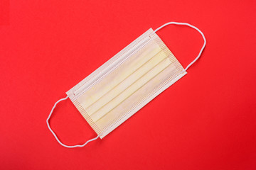 Medical mask on a colored background, a means of protection against coronovirus and epidemic