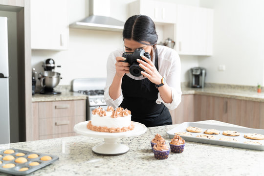 Young Female Food Photographer Taking Pictures Of Cake