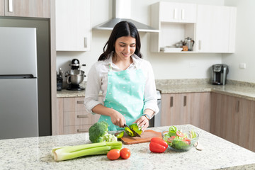 Good Looking Housewife Enjoying Preparing Salad At Home