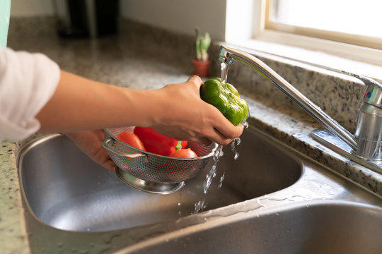 Young Woman Cleaning Vegetables At Home - Powered by Adobe