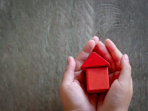 Child hands holding red model house, family, homeless, home loan and home protect insurance concept. Home sweet home.