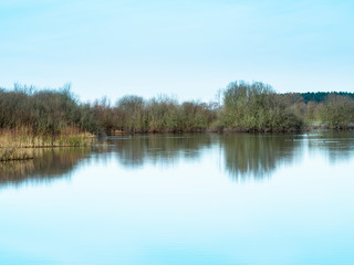Fototapeta na wymiar Reflections in the calm waters of the annually flooded wetlands at Wheldrake Ings, North Yorkshire, England