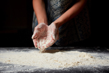 Baker prepares homemade cakes. Professional Female cook sprinkles dough with flour, prepared for baked bread