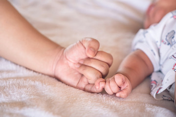 Mom and baby making a pinkie promise. Mother's love concept.