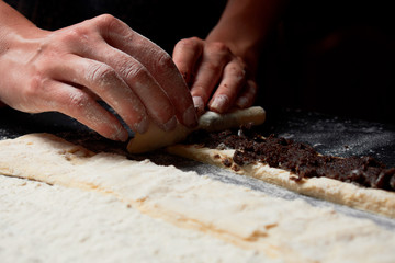 Baker prepares homemade cakes. Professional Female cook sprinkles dough with flour, prepared for baked bread