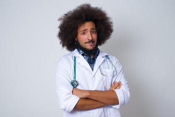 African American doctor man bitting her mouth and looking worried and scared crossing arms, worry and doubt.