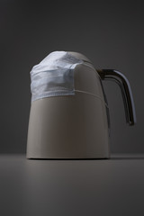 Coronavirus (Corona virus) concept:Kettle put mask to fight against Corona virus. The concept of the fight against the virus, the decline in production and supply of goods from China and other country