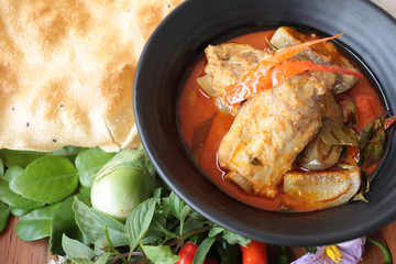 Thai food spicy pork spare rib red curry with crispy rice cake, homemade organic vegetable and herbs asian culinary.