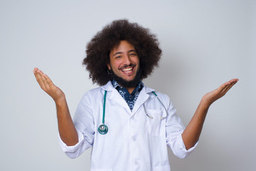 Cheerful doctor man wearing making a welcome gesture raising arms over head isolated on white background.