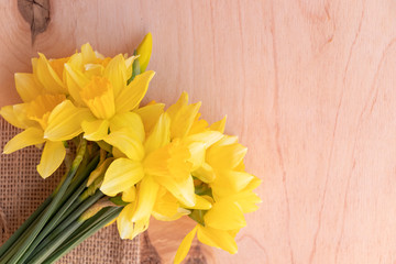 Yellow daffodils on a wooden background. Bouquet of spring flowers. Warm weather.