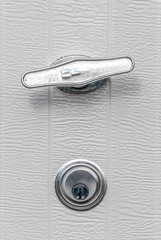 Close up of chrome finish T Handle garage door opener outside mounting handles hardware and lock...