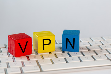 colorful blocks with the letters VPN which stand for virtual private network. The blocks are on a bright computer keyboard and isolated with white background