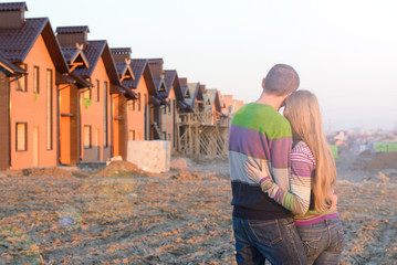 Rear view of young couple looking at their new house.