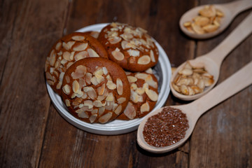 Almond Chip Cookies. Almonds on a round homemade cookie. Still life, food closeup on a wooden table. Appetizing pastries.