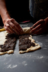 Professional Female cook sprinkles dough with flour, prepared for baked bread