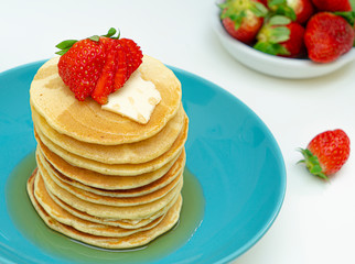 stack of pancakes with maple syrup and berries