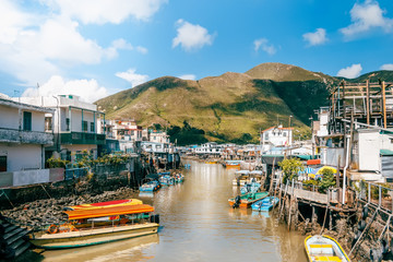 Traditional Asian Fishing Village and River under Blue Sky and Mountain in Hong Kong, China