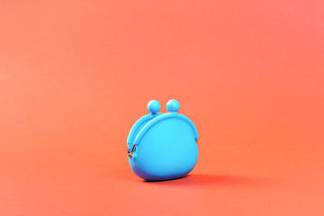 Blue coins money purse or pouch empty and open on orange background. Savings or costs zine concept with copy space. Earnings, income or money management concept